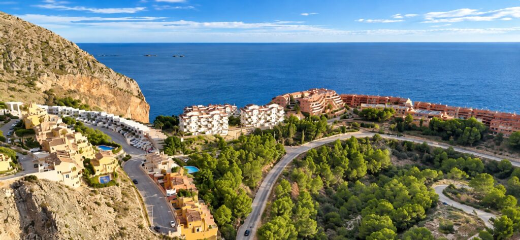 Vista aérea de la costa con acantilado, urbanizaciones, pinar y el mar al fondo