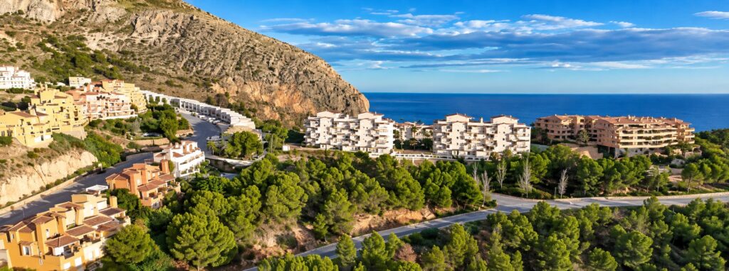 Vista aérea del pinar, carreteras y edificios residenciales junto al mar